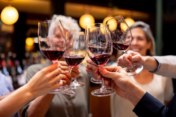 Close-up on a happy group of people making a toast at a wine tasting - The Beacon Inn