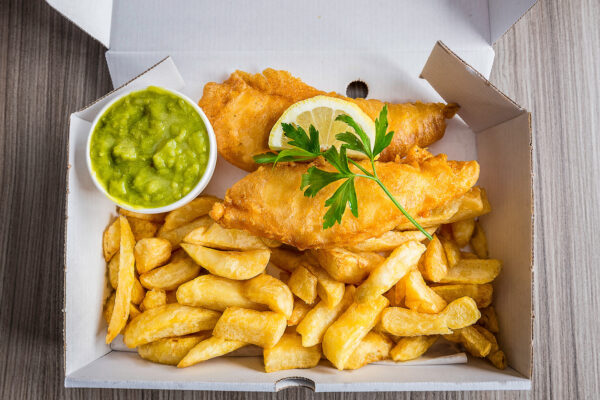 Fish and chips with peas and slice of lemon and garnish - The Beacon Inn